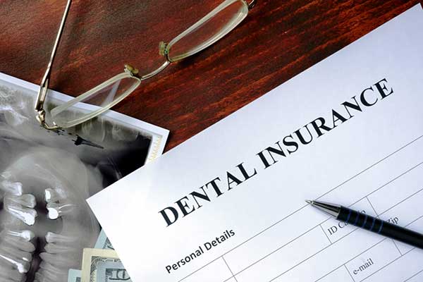 A dental insurance form with a pen to make a claim.