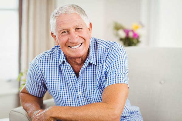 An elderly man relaxed and smiling.