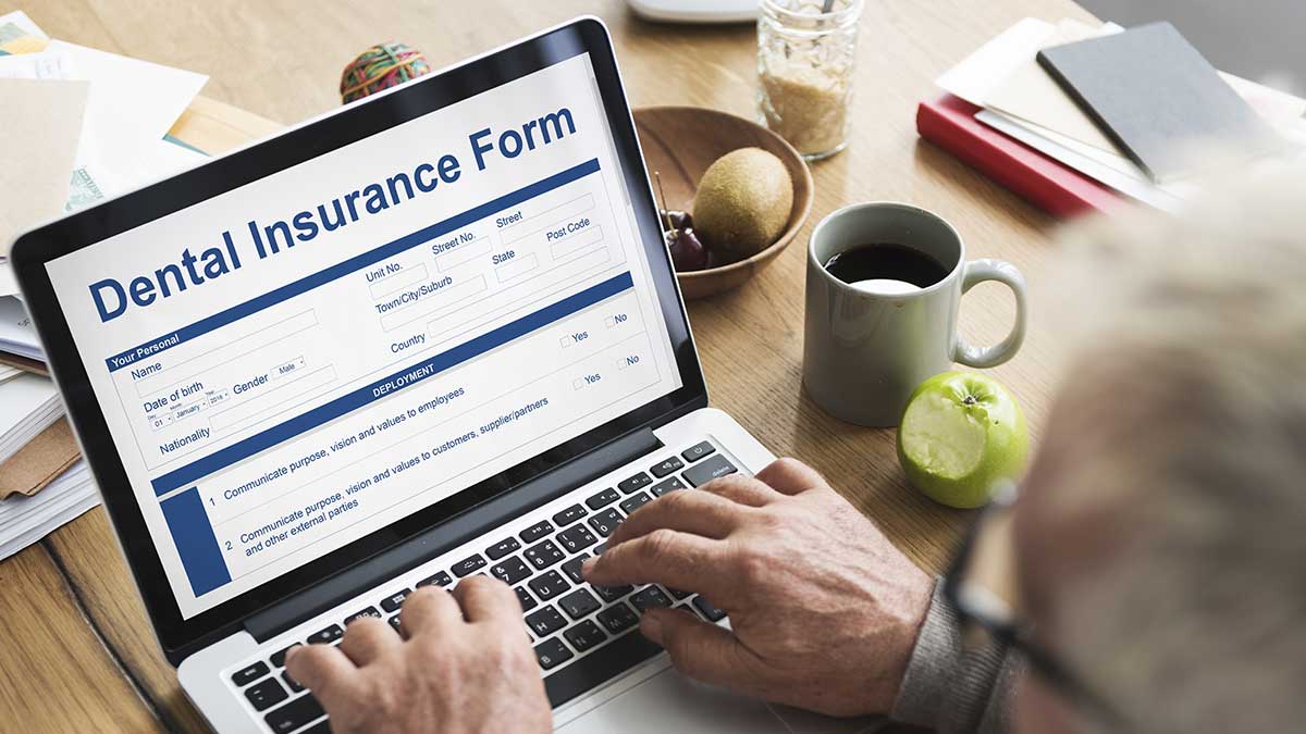 An elderly man researching dental insurance.