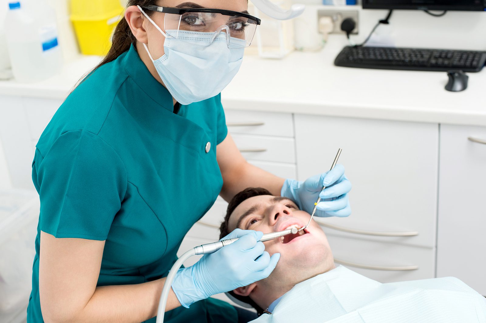 A dentist is working with the patient in his mouth.