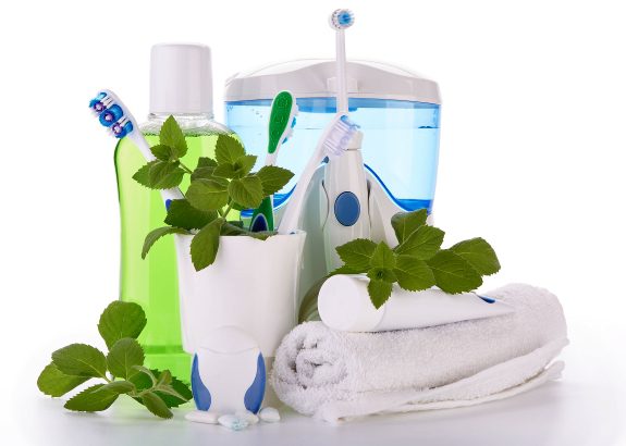 A table with toothbrushes, toothpaste and tooth paste.