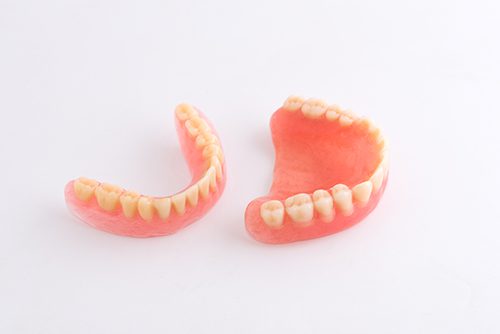 Two fake teeth are sitting on a table.