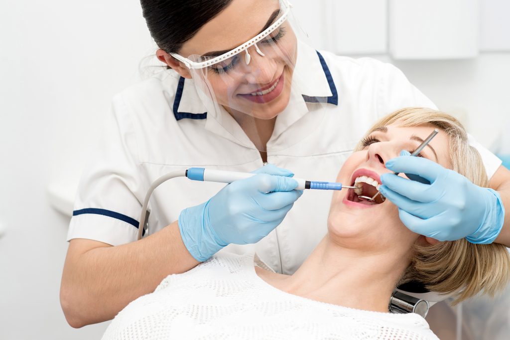 A dentist is performing an exam on the patient.