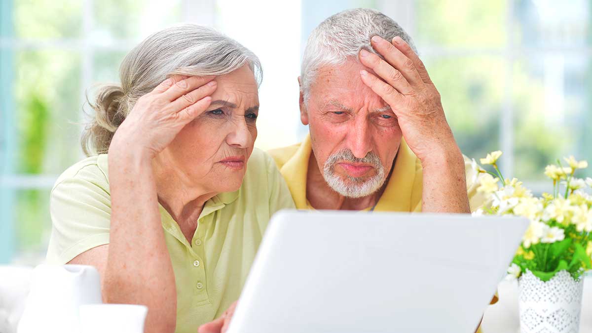 An elderly couple looking at a computer perplexed.