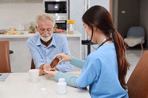 A woman is giving medicine to an old man.