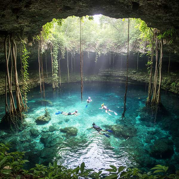 Snorkelers swimming is a Cenote in Mexico.